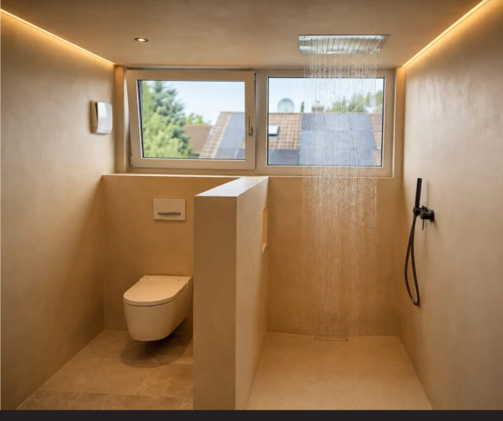 Fugenloses Bad mit laufender Regendusche in warmer mineralischer Oberfläche