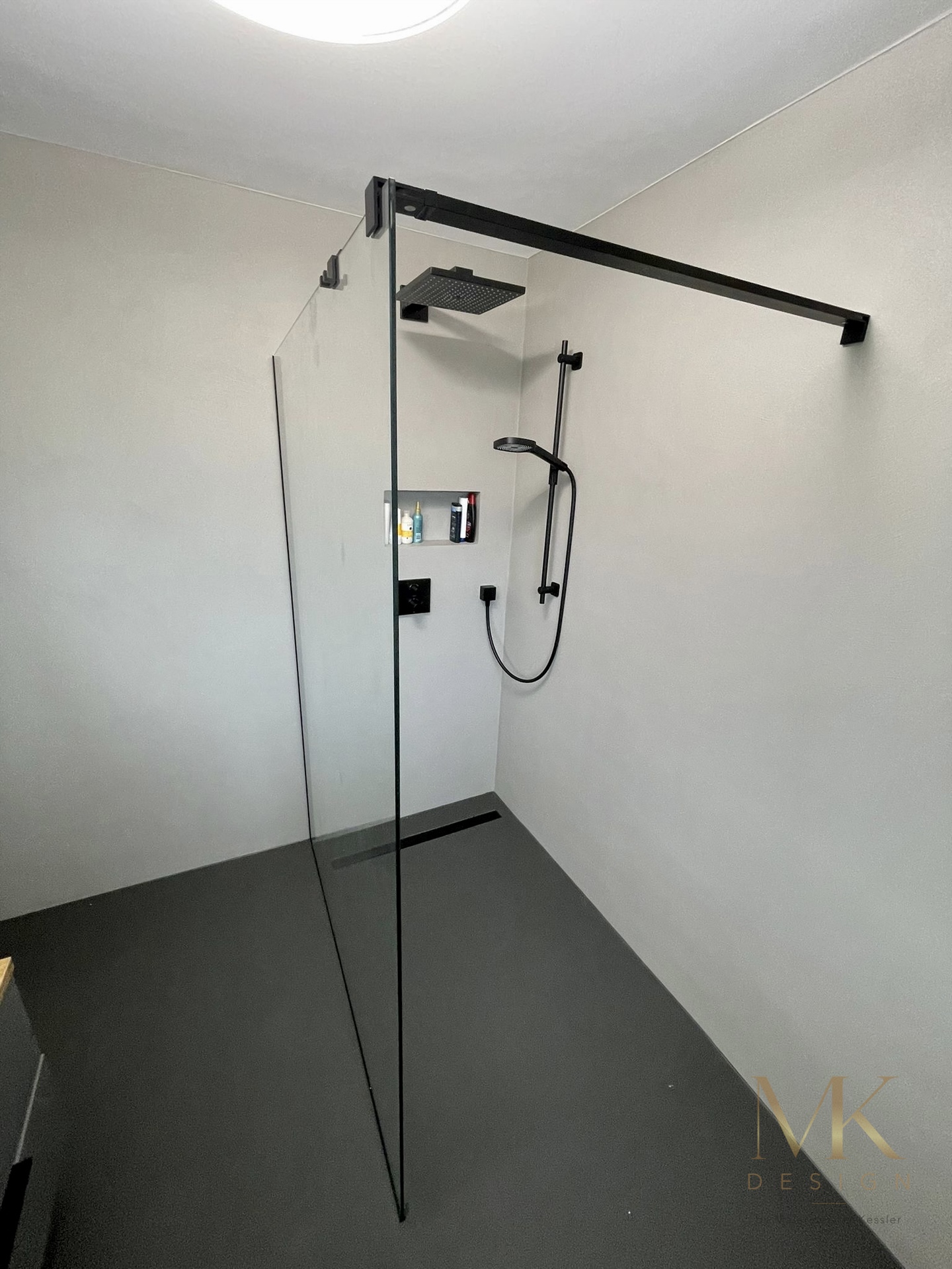 Fugenlose Dusche mit schwarzen Armaturen und Glasabtrennung in Herrenberg-Kayh