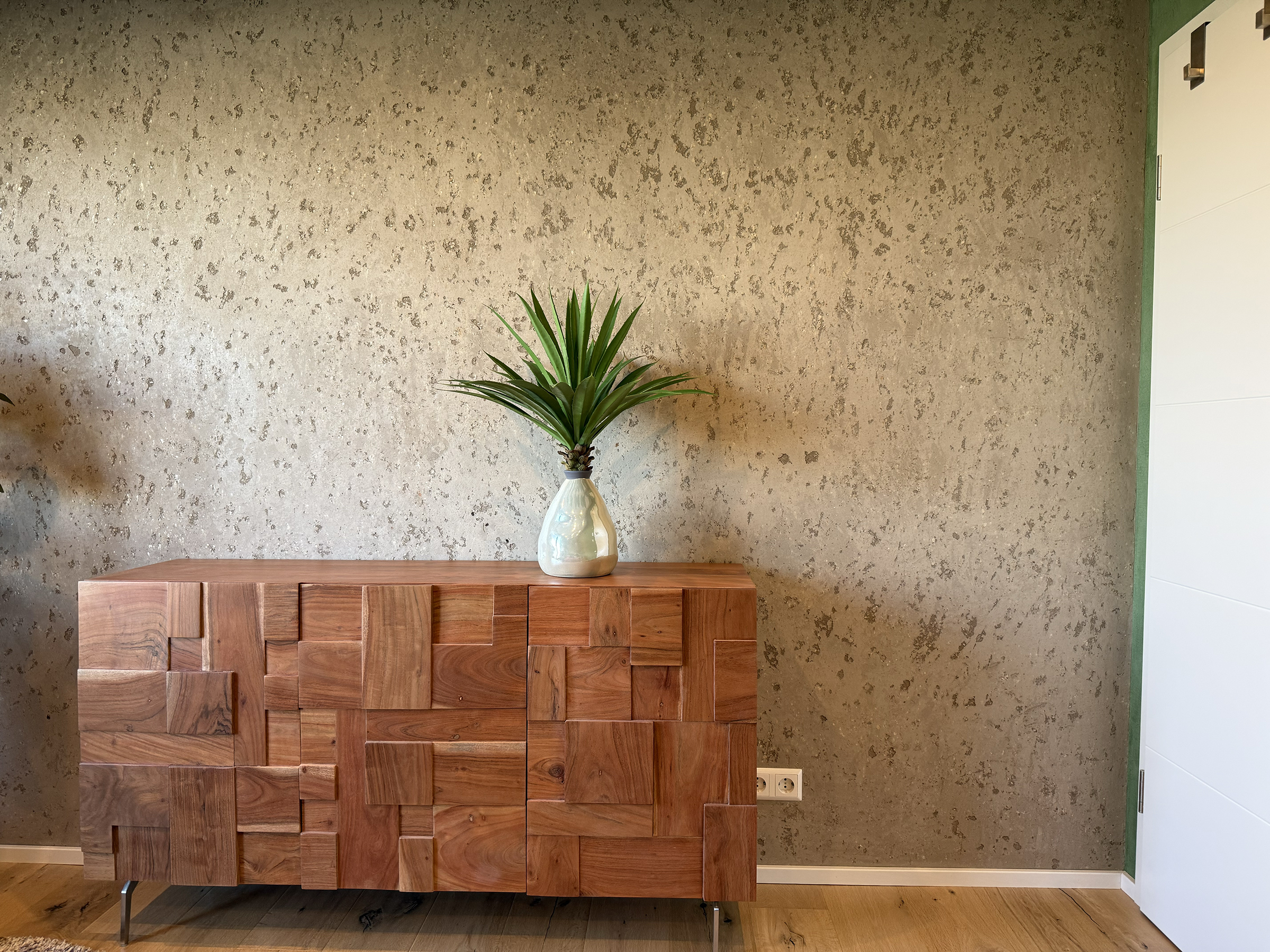 Mineralische Wandgestaltung mit Sideboard und Vase
