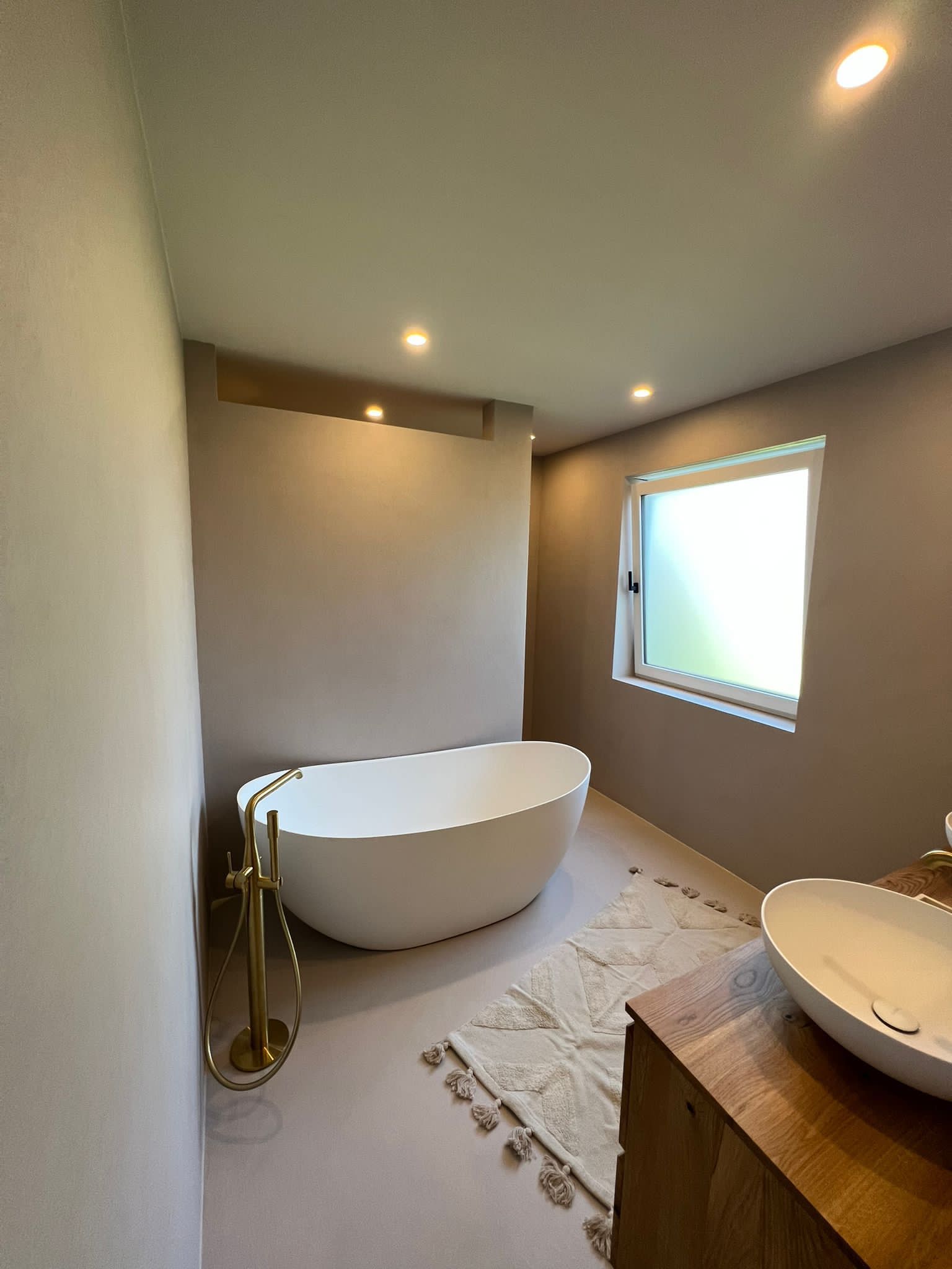 Freistehende Badewanne im fugenlosen Badezimmer in Rottenburg