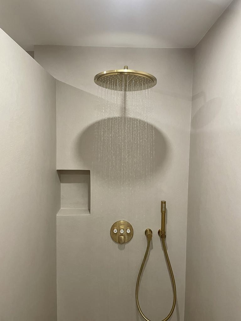 Fugenlose Dusche mit goldener Regendusche und Armaturen in Rottenburg
