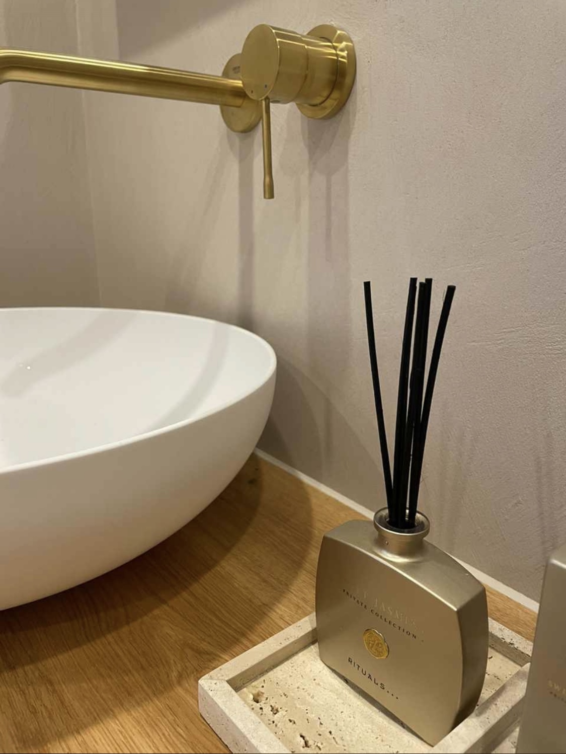 Detail einer goldenen Wandarmatur im fugenlosen Badezimmer in Rottenburg